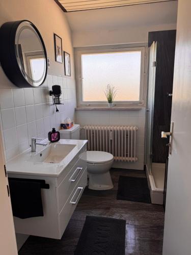 a bathroom with a sink and a toilet and a window at Auszeit in Niedereschach