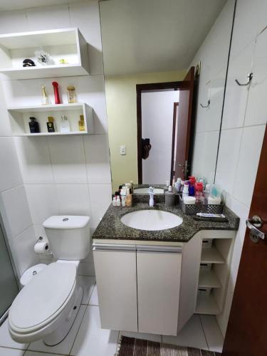 a bathroom with a toilet and a sink and a mirror at Apartamento Park Vinhais in São Luís