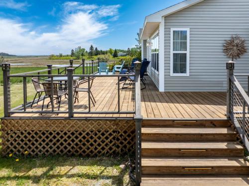 a wooden deck with a table and chairs on a house at Seascape Serenity with Epic Coastal Views! in Lubec