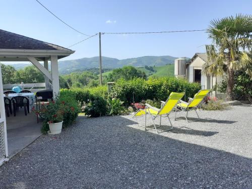 a group of chairs and a table in a yard at Gite au pied de la montagne avec tous commerces in Arette