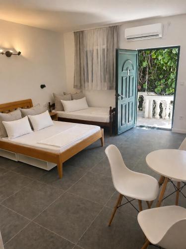 a room with two beds and a table and chairs at Studios Annie in Bijela