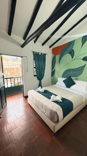 a bedroom with a large bed with a painting on the wall at Tour La Matrona in Villa de Leyva