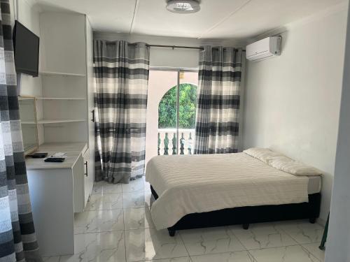 a small bedroom with a bed and a window at 85 Hidden Gem in Newlands