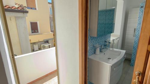a bathroom with a sink and a toilet and a mirror at Casa Gala in Mamoiada