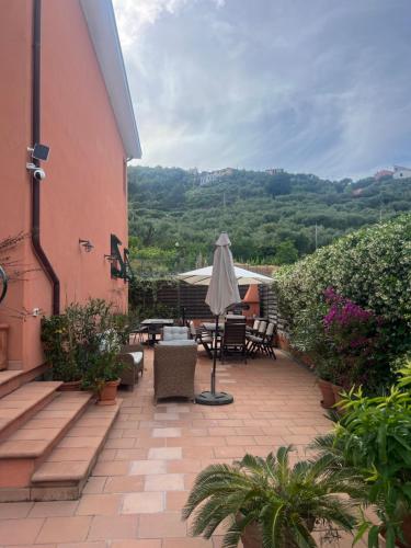 a patio with an umbrella and tables and chairs at Casa Alma in Sestri Levante
