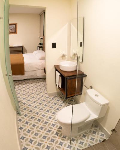 a bathroom with a toilet and a sink at Hotel Posada de Piedra in Orizaba