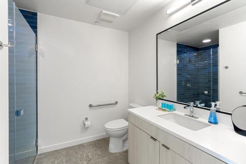 a bathroom with a toilet and a sink and a mirror at Modern Hollywood Studio, Pool Parking Gym in Los Angeles