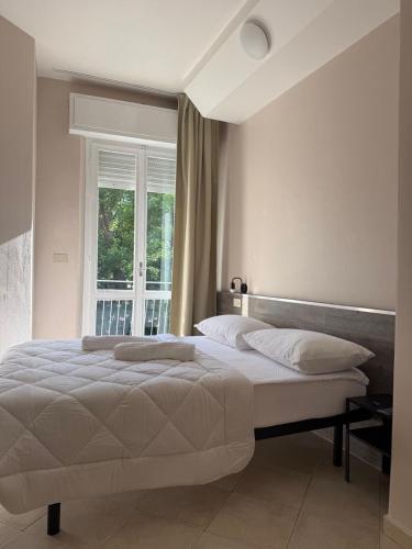 a bedroom with a large bed with a window at Hotel BENGASI Marina Centro in Rimini