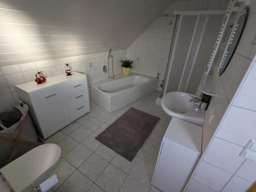 a bathroom with a tub and a sink and a toilet at FeWo am Heimlisberg in Friesenheim