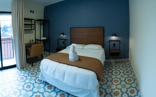 a bedroom with a large bed with a white vase on it at Hotel Posada de Piedra in Orizaba