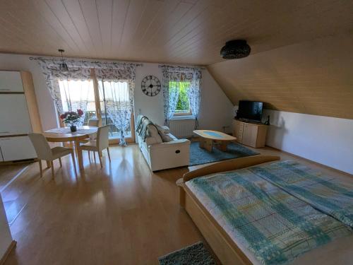 a bedroom with a bed and a table and chairs at FeWo am Heimlisberg in Friesenheim