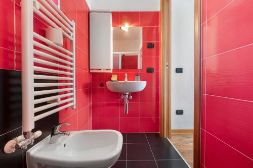 a bathroom with a sink and a red wall at Aphrodite's Garden in Gera Lario