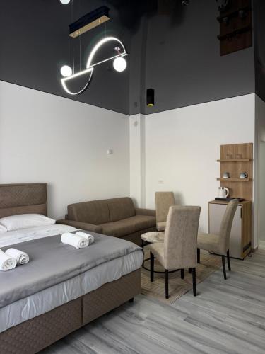 a bedroom with a bed and a couch and chairs at Hotel Ricardo Residence in Ulcinj