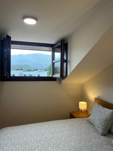 a bedroom with a bed and a large window at Apartamento La Marquesa in Llanes