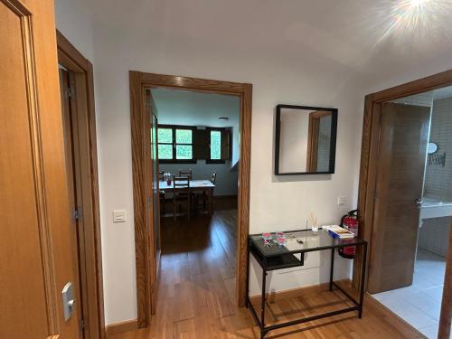a living room with a glass table and a mirror at Apartamento La Marquesa in Llanes