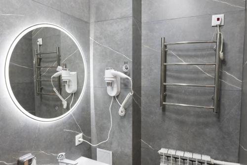 a bathroom with a mirror and a sink at Apricot Lodge in Bishkek