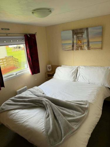 a bed with a blanket on it in a bedroom at ScotThistle in Kirkcowan