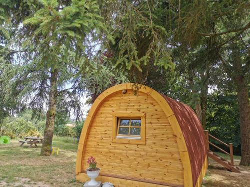 a small wooden shed with a window in a yard at La Cabane MIMOSA in Saint-Malo-du-Bois