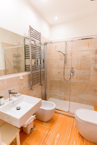 a bathroom with a toilet and a sink and a shower at Divine Bed & Breakfast in Rome