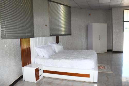 a bedroom with a bed with white sheets and pillows at Royal Palace Hotel Harar in Hārer