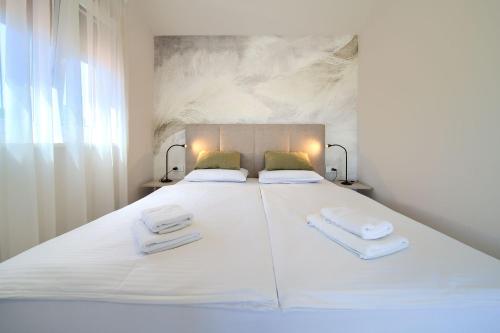 a large white bed with two towels on it at Villa Monika in Krk