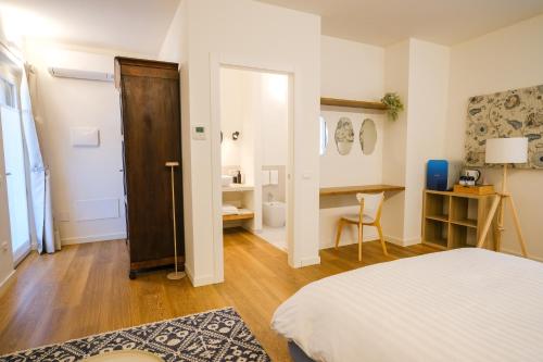 a bedroom with a bed and a table and a desk at L'Upupa Bed & Breakfast in Muscoline