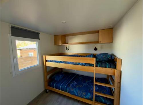 two bunk beds in a small room with a window at Bungalow à la mer in Villeneuve-en-Retz