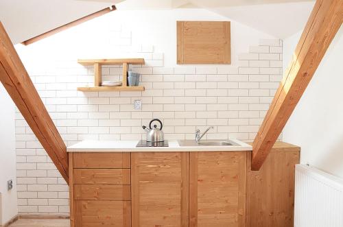 a kitchen with wooden cabinets and a sink at Apartmány Nad Pivovarem in Havířov