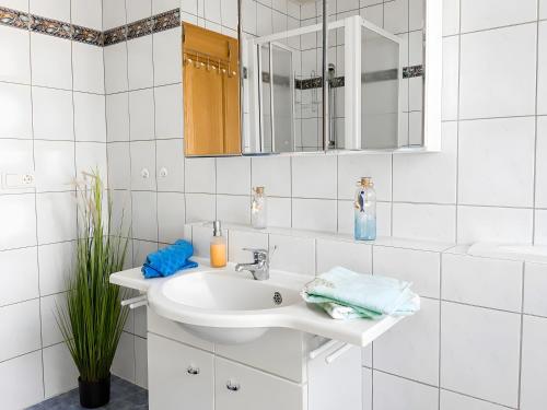 a white bathroom with a sink and a mirror at Ferienwohnung Frischkorn in Steinau an der Straße