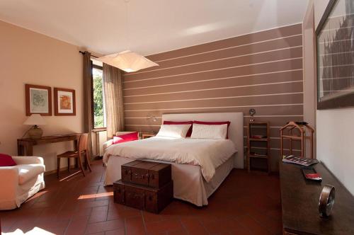a bedroom with a bed and a chair and a table at La Corte e l'Uva in Olgiate Comasco