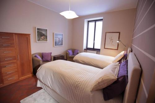 a bedroom with two beds and a couch at La Corte e l'Uva in Olgiate Comasco
