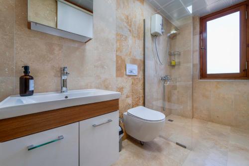 a bathroom with a toilet and a sink and a shower at Istlada Taş Ev Apart - Kekova Island View in Demre