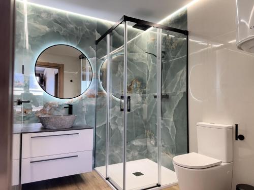 a bathroom with a shower with a toilet and a mirror at Flower Beach Helgueras 2 - 6092 in Noja