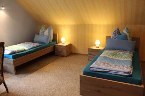 a bedroom with two beds and two night stands at Ferienwohnung Andrea ist mit 1 oder 2 Schlafzimmer in Grünebach Buchbar in Grünebach