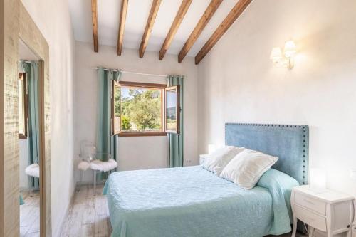 a bedroom with a blue bed and a window at Villa Maria in Port de Pollensa
