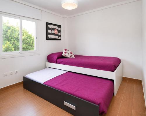 a bedroom with two beds with purple sheets at VILLA MIRAMAR in Peniscola