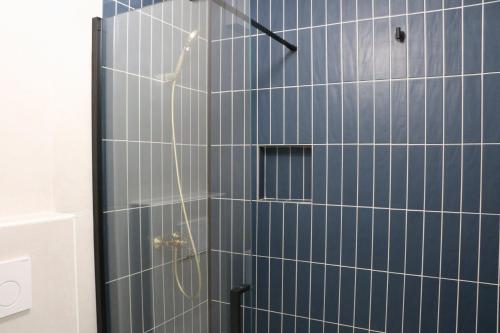 a bathroom with a shower with blue tiles at Between Pines&Sea Strunjan in Strunjan
