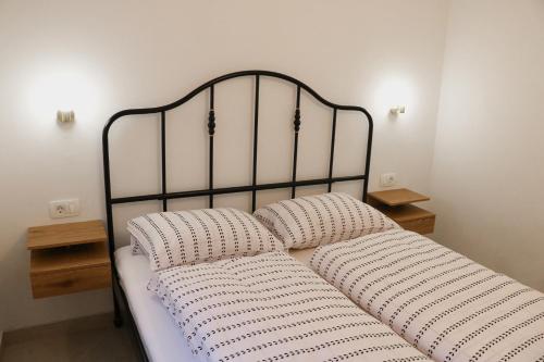 a bed with two pillows on it in a room at Between Pines&Sea Strunjan in Strunjan