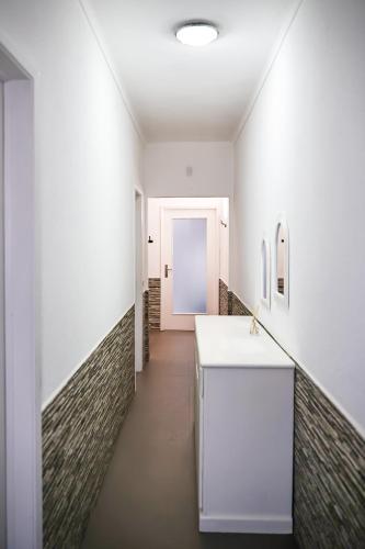 a bathroom with a white counter and a hallway at Casa a 2 minutos a pé de piscina natural in Ponta Delgada