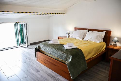a bedroom with a bed with two towels on it at Casa a 2 minutos a pé de piscina natural in Ponta Delgada