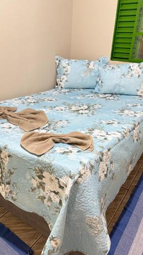 a bed with a blue comforter and pillows on it at Cantinho aconchego in Naviraí