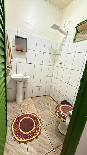 a bathroom with a toilet and two mats on the floor at Cantinho aconchego in Naviraí