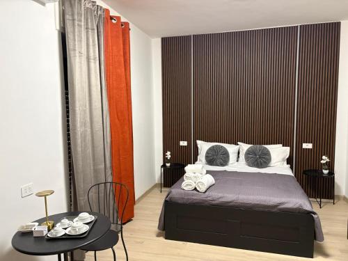 a bedroom with a bed with a black headboard and a table at B&B Mary House con vasca idromassaggio al centro di Salerno in Salerno