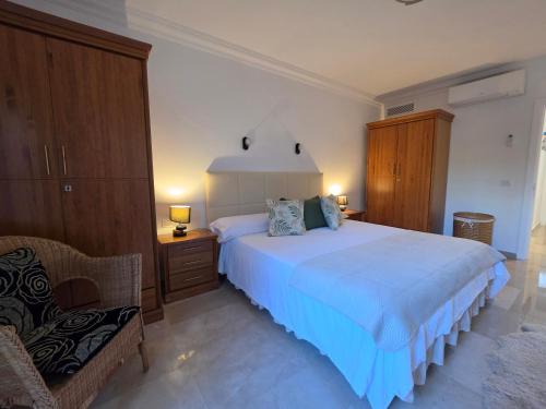 a bedroom with a large white bed and a chair at Villa Torbellino, Diseño, Privacidad y Confort in La Playa de Tauro