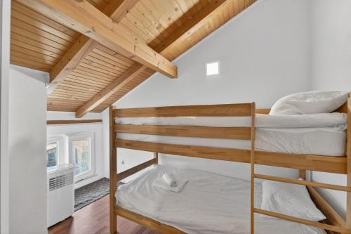 a bedroom with two bunk beds and a wooden ceiling at Izba Vacation Home in Međugorje