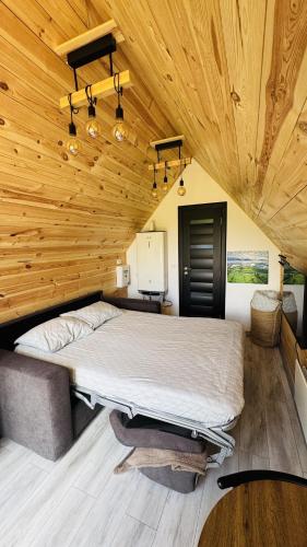 a large bed in a room with a wooden ceiling at Tiny A-Frame Cabin with Private Hot Tub & Views - Perfect for 2 in Şelari