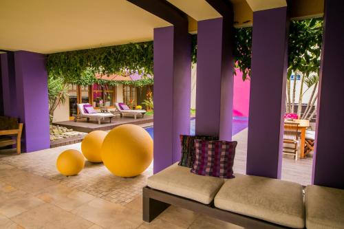 a living room with purple pillars and a couch and chairs at Apart-Hotel Casa Serena in Guatemala