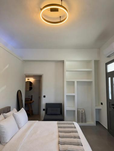 a bedroom with a large bed and a chair at Ovio II in Kampos Paros