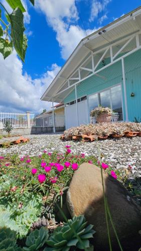 a house with pink flowers in front of it at Casa Privativa no Centro de Urubici - Casa Doce Luar in Urubici
