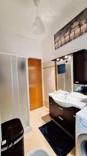 a bathroom with a sink and a large mirror at Parma soggiorni brevi in Parma